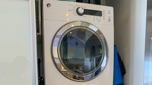 Una lavadora y secadora compacta de dos puertas, con panel de control y pantalla digital.