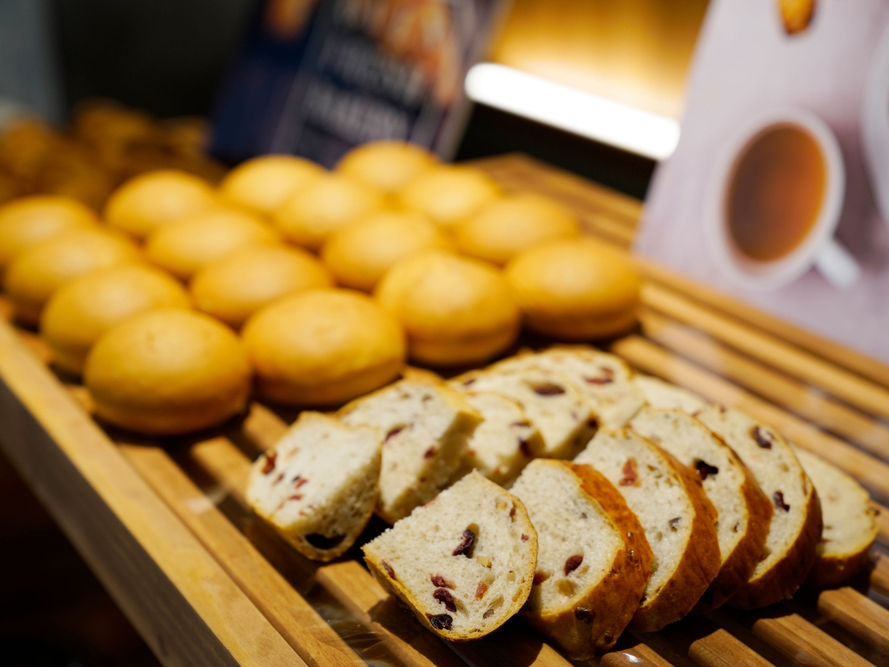 Exposição de pães e fatias de pão sobre uma tábua de madeira.
