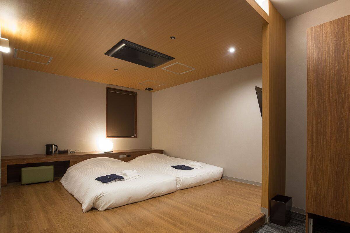 Une pièce comprenant un lit, un bureau, une chaise et une poubelle.