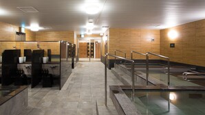 Ein modernes Hallenbad mit deutlich abgegrenzten Bahnen, einem Umkleidebereich und einem hell erleuchteten Eingang.
