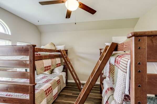 A dormitory room with bunk beds, a ceiling fan, and a large window providing natural light. - Tiara Mansion 8Bdrm 5 Bth 5 acre (Fort Worth)