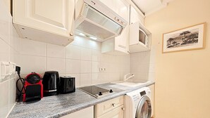 Une cuisine équipée d’un lave-linge, d’une machine à café et d’un grille-pain.