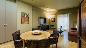 A modern living room with a round dining table, wicker chairs, a flat-screen TV, and a sofa. - NEW APARTMENT - Central Athens - Kolonaki, luxury modern flat.  (Athina)