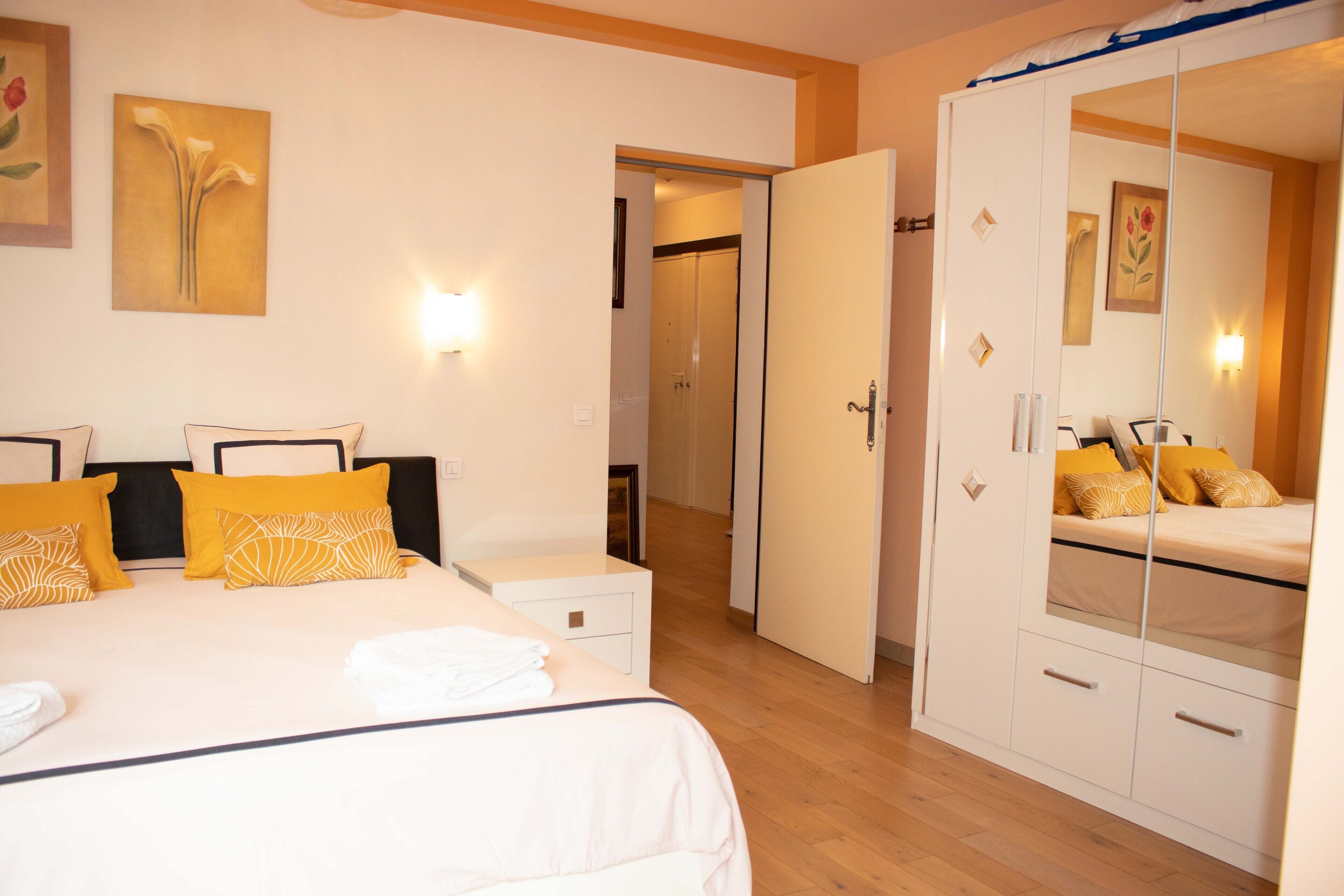 Een hotelkamer met een bed, nachtkastjes, een garderobe en een spiegel.