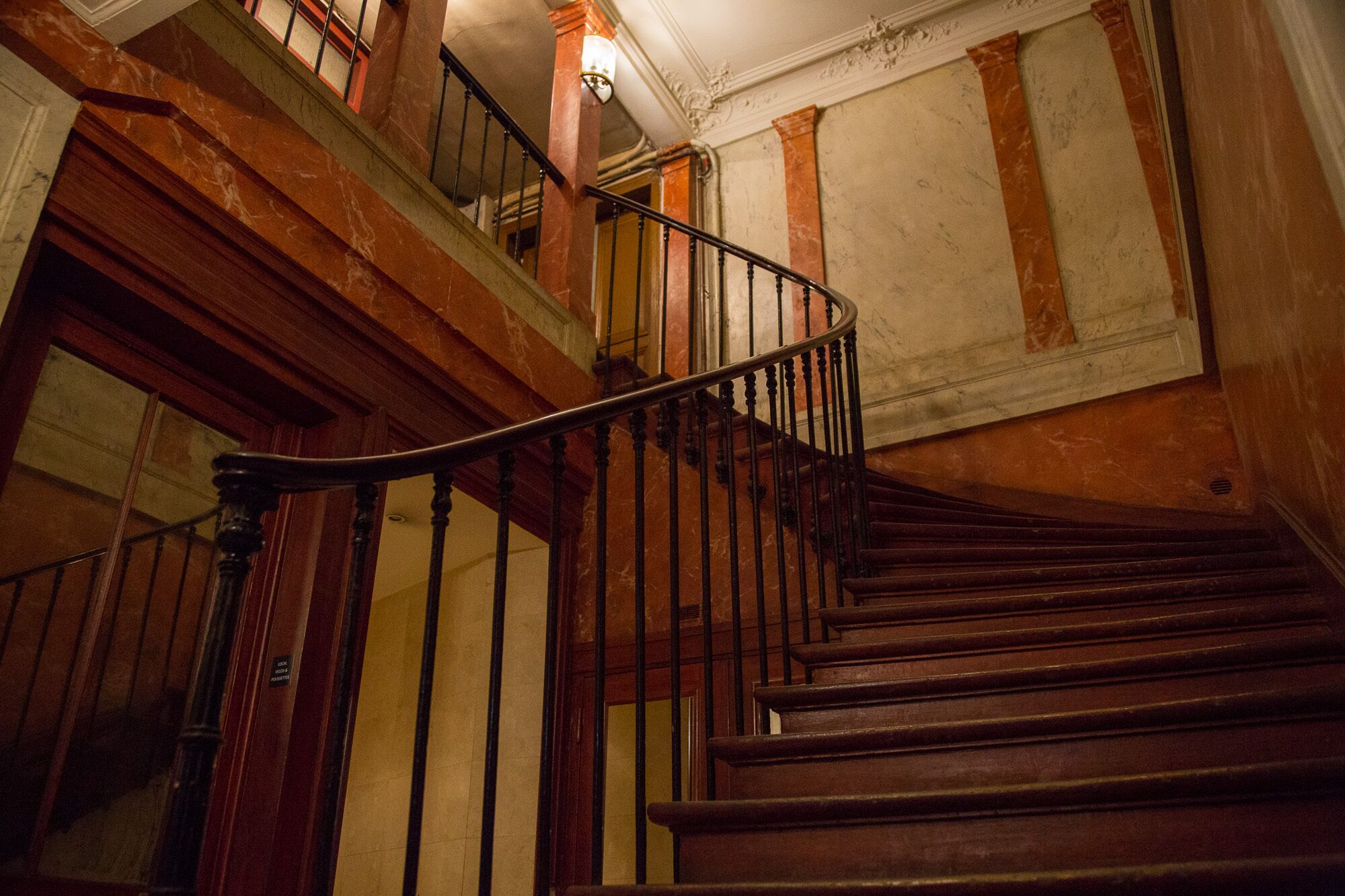 Un escalier en bois avec une rampe en métal noir, menant à l’étage supérieur.