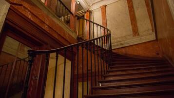 Un escalier en bois avec une rampe en métal noir, menant à l’étage supérieur.