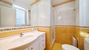 A bathroom with a white sink, a toilet, and a shower area. - Studio Commandant André 13 by Viva Riviera (Cannes)