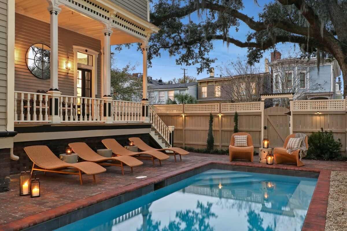 A pool area with lounge chairs and a covered porch.