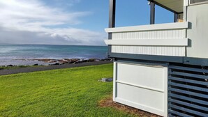 A beachfront property with a white exterior, a grassy lawn, and a view of the sea. - Classic Shack -  Absolute Beachfront.  Winter off peak special! (Point Turton)