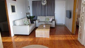 A living room with a sofa set, a coffee table, and a television. - Classic Shack -  Absolute Beachfront.  Winter off peak special! (Point Turton)