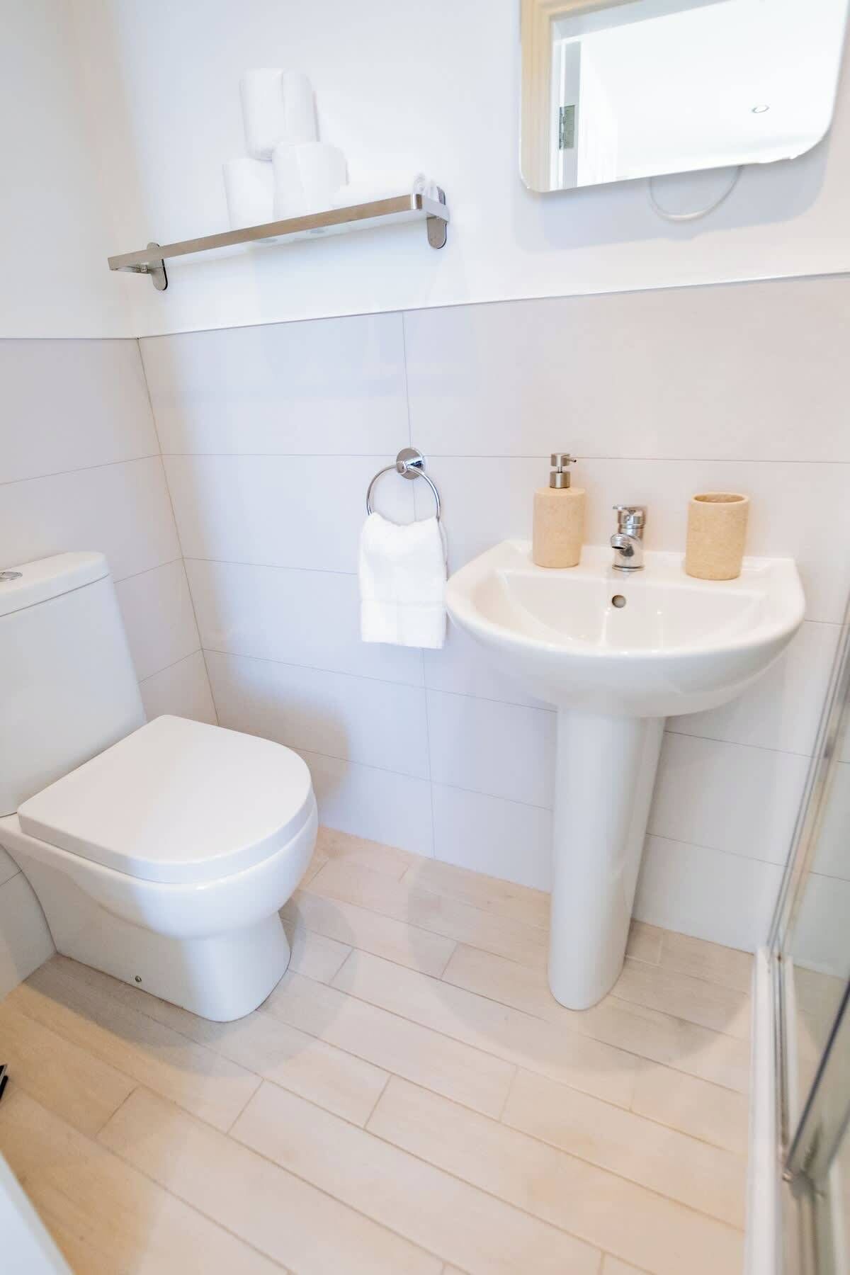 A small, clean bathroom with a toilet, sink, and towel rack.