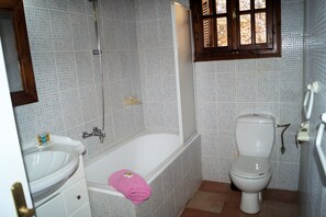 A bathroom with a bathtub, a toilet, and a sink. - Holiday home in Historical village of Kefalonia (Troianata)