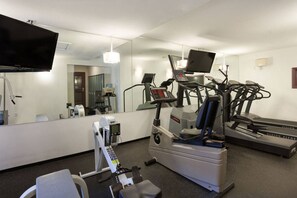 A fitness room with a treadmill, elliptical, and stationary bike, a TV, and a mirror. - Superb 2BR/2BA Steps to Gondola - AC + Gym! (Whistler)