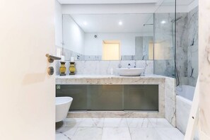 Bañera con ducha, secador de pelo, bidet, toallas