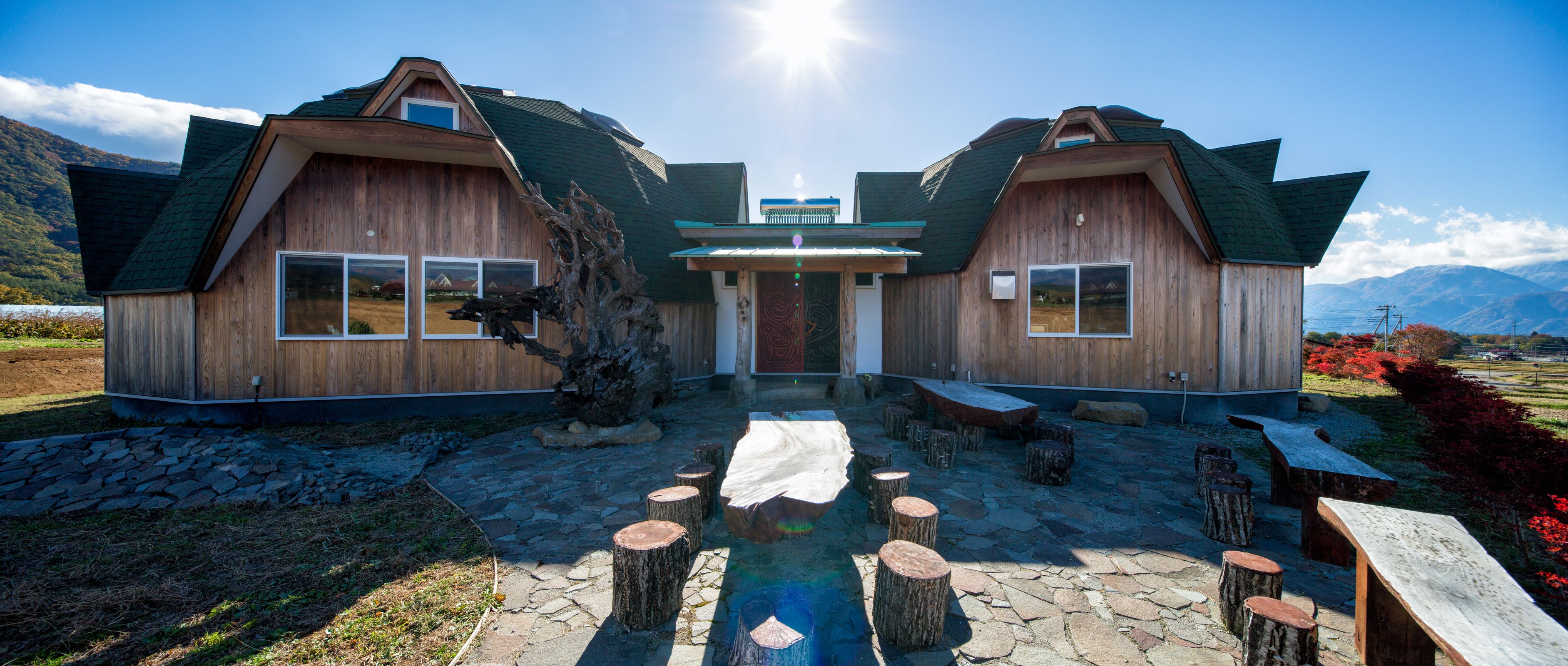 A wooden cabin with a stone-paved entrance and wooden benches.
