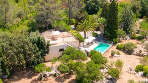 A villa with a swimming pool, surrounded by dense greenery and rocky terrain. - Can Company - Beautiful finca with pool and garden in Campanet (Campanet)