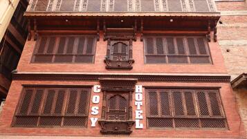 A traditional building with a sign reading "Cosy Hotel".