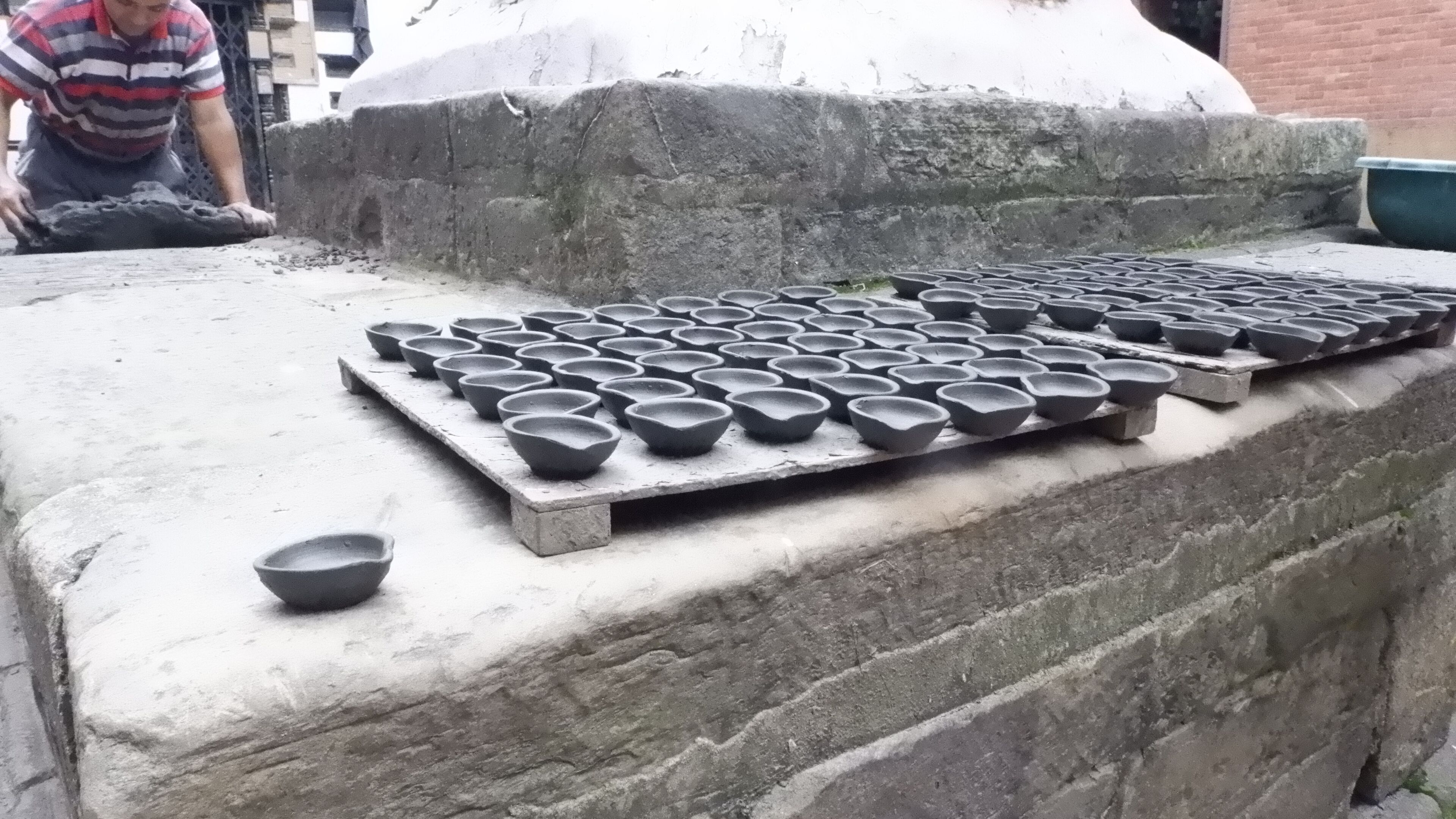 A stone structure with multiple black bowls arranged on a flat surface.