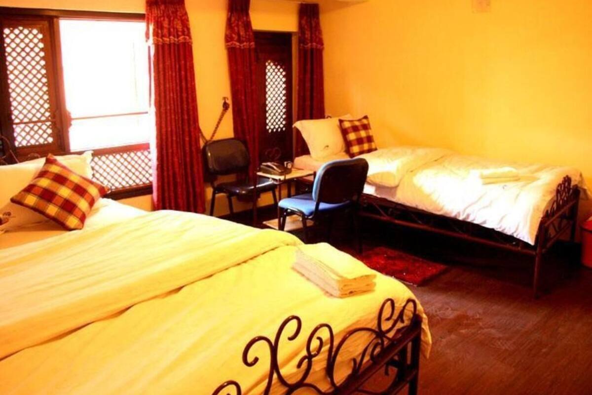 A room with two beds, a desk, and a chair.