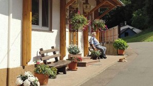 A building with a sign reading "Gasthaus Pension Zum Spälarwald" and a wooden bench outside.