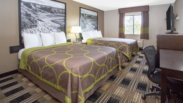 A hotel room with two beds, a desk, a chair, a TV, and large landscape paintings on the walls. - Super 8 Billings (Billings)