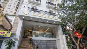 L’entrée de l’hôtel Lieber se distingue par sa façade en marbre, un escalier menant à l’entrée et une grande fenêtre en verre.