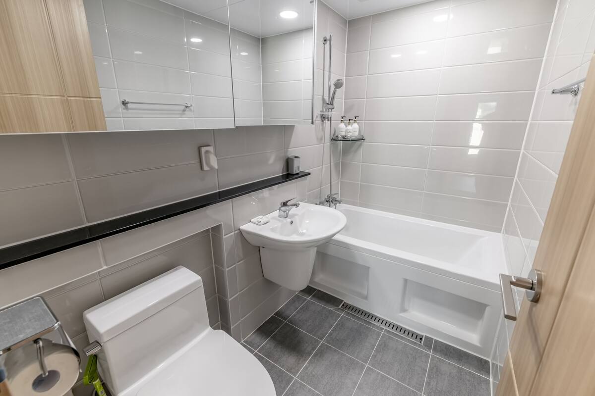 Une salle de bain moderne équipée de toilettes, d’un lavabo et d’une baignoire.
