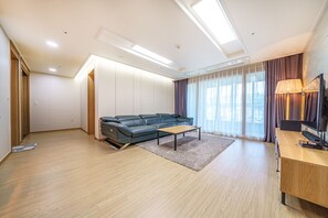 Standardsuite - 3 soveværelser | Opholdsområde | 65-tommers fladskærms-tv med kabelkanaler, gulvvarme