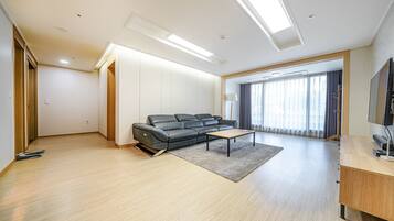 A modern living room with a sofa, a coffee table, and a TV.