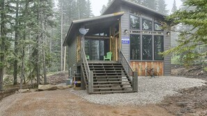 A cabin with a wooden staircase leading to a porch, surrounded by trees. - New Venture- 3BR Cabin by Terry Peak (Lead)