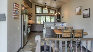 A modern kitchen with a dining area, large windows, and a ceiling fan. - New Venture- 3BR Cabin by Terry Peak (Lead)