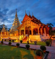 A temple complex with a large stupa and a traditional building with ornate architecture.