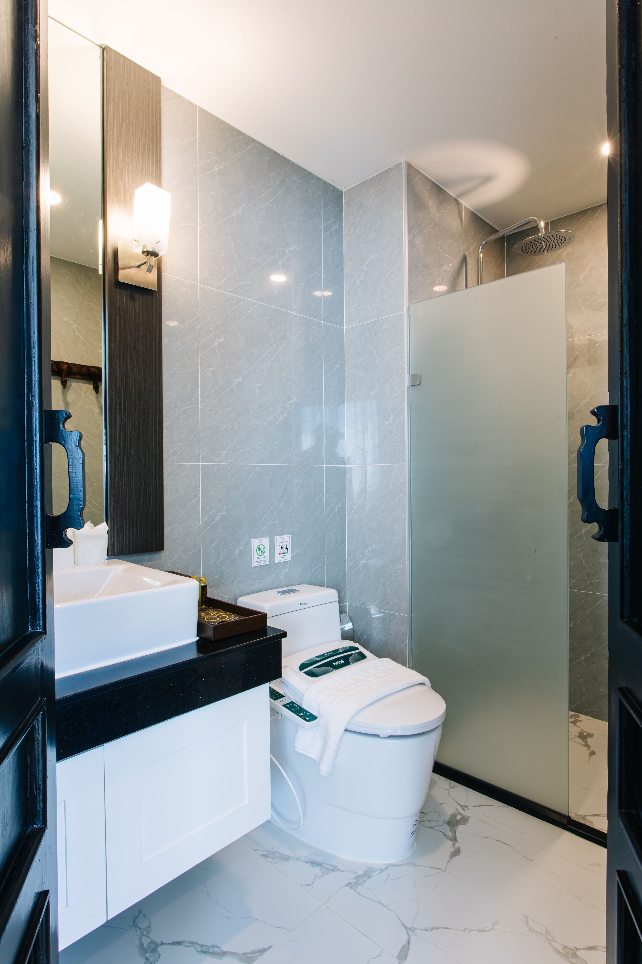 A modern bathroom with a white sink, toilet, and shower.