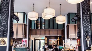 A hotel lobby with multiple seating areas, a reception desk, and a staircase leading to an upper level. - The Experience Walking Street Chiang Mai (Chiang Mai)