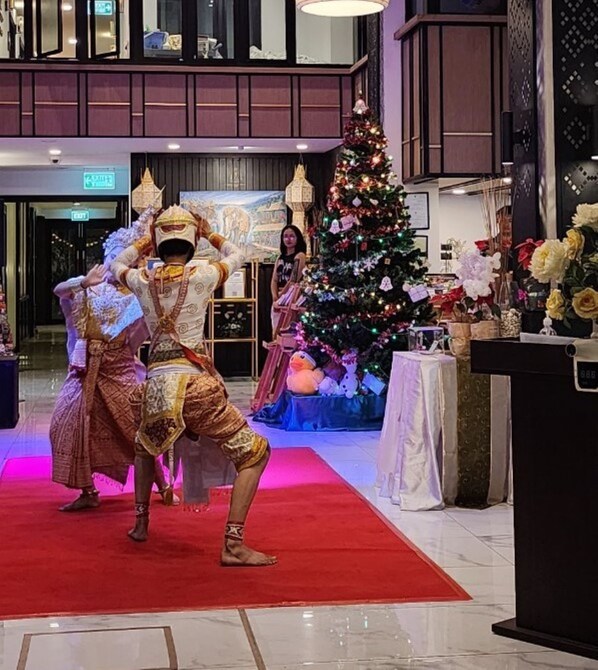 Ambiente festivo en un espacio interior con un árbol de Navidad y una alfombra roja.