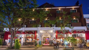 A hotel with a central entrance, outdoor seating, and a well-lit facade. - The Experience Walking Street Chiang Mai (Chiang Mai)