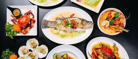 A variety of seafood dishes arranged on plates.