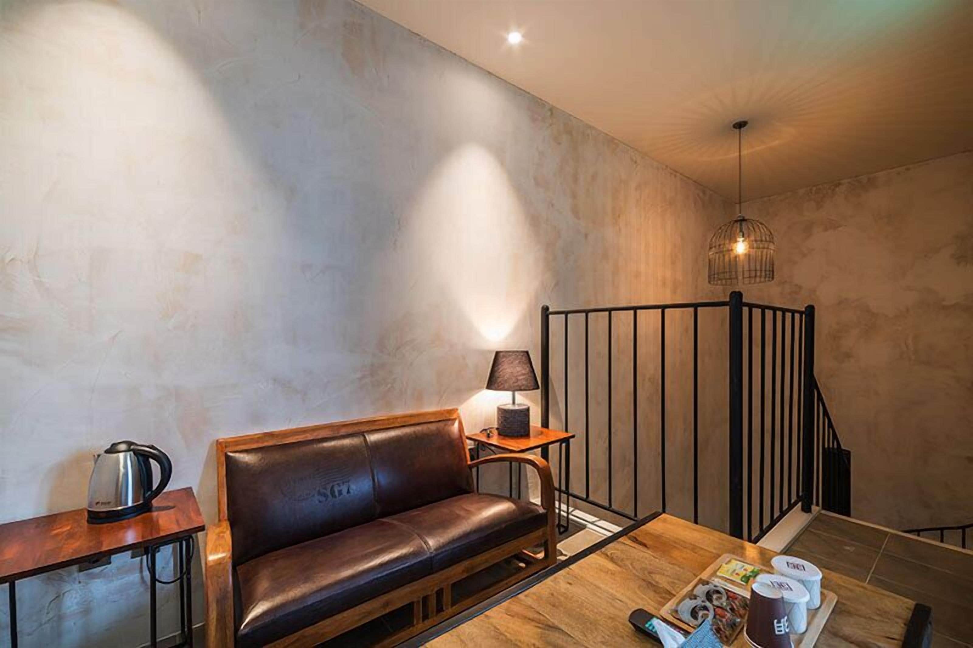 Ein modernes Wohnzimmer mit einem Ledersofa, einem Holztisch, einer Lampe und einer Zeitschrift.