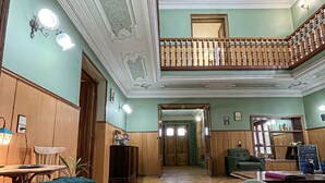 A spacious lobby with a wooden floor, a staircase, and a reception desk. - Guest House Top Floor (Telavi)