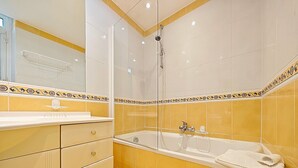 A bathroom with a bathtub, a shower, and a vanity with drawers. - Studio Commandant André 22 by Viva Riviera (Cannes)