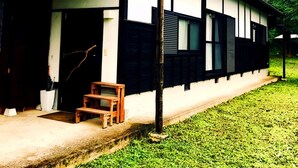 Una casa japonesa tradicional con fachada de madera, tejado de tejas y un pequeño banco de madera en el exterior.