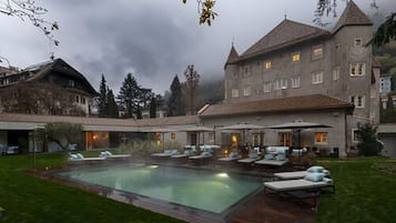 Una piscina al aire libre, camas de piscina gratis, sombrillas