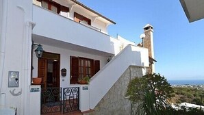 A white building with a stone staircase, wooden shutters, and a view of the sea. - Large apartment sleeping 9 can accommodate 2 families (Barano d'Ischia)