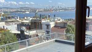 A view from a window overlooking a cityscape with buildings and a body of water. - Terrace Guesthouse (Istanbul)
