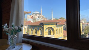 A view of a historic building with a dome and minarets through a window. - Terrace Guesthouse (Istanbul)