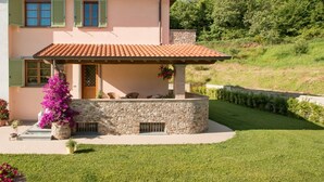 A two-story house with a stone facade, green shutters, and a tiled roof. - Il Poggiolo (Camaiore)