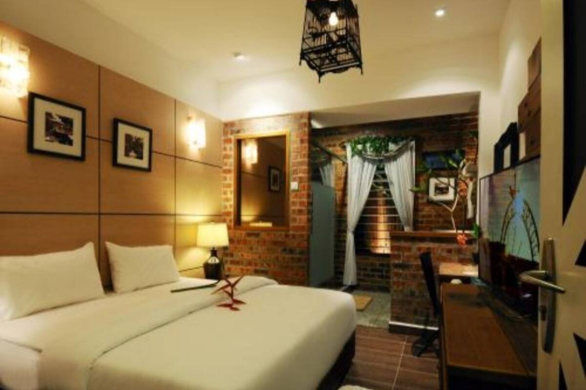 A hotel room with a large bed, a desk, and a staircase leading to an outdoor area.