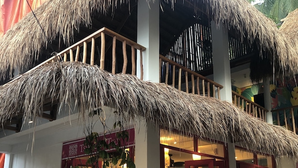 A building with a thatched roof and a red-framed entrance. - Way Shack Hostel (Oslob)
