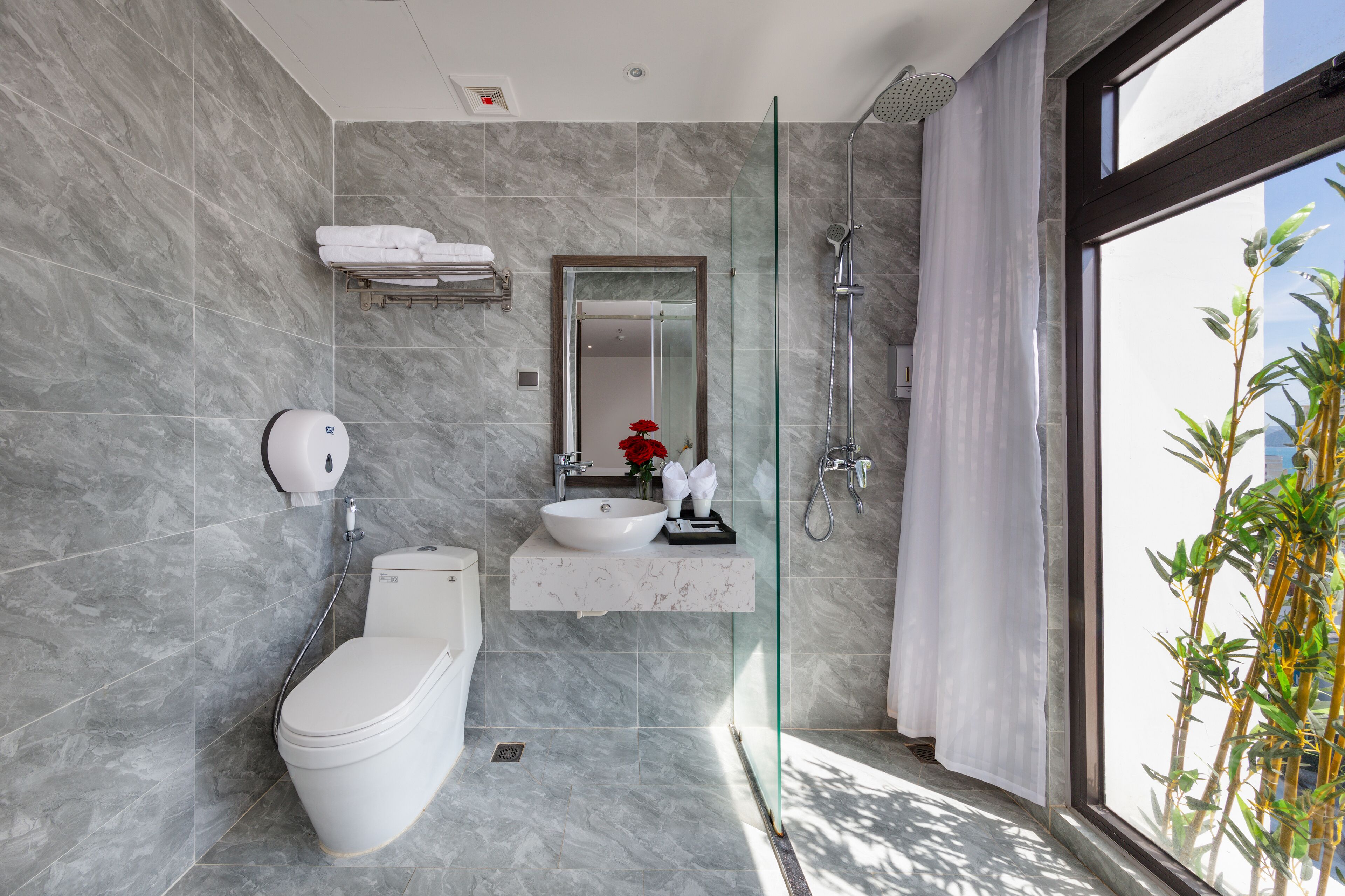 A modern bathroom with a toilet, sink, and shower.