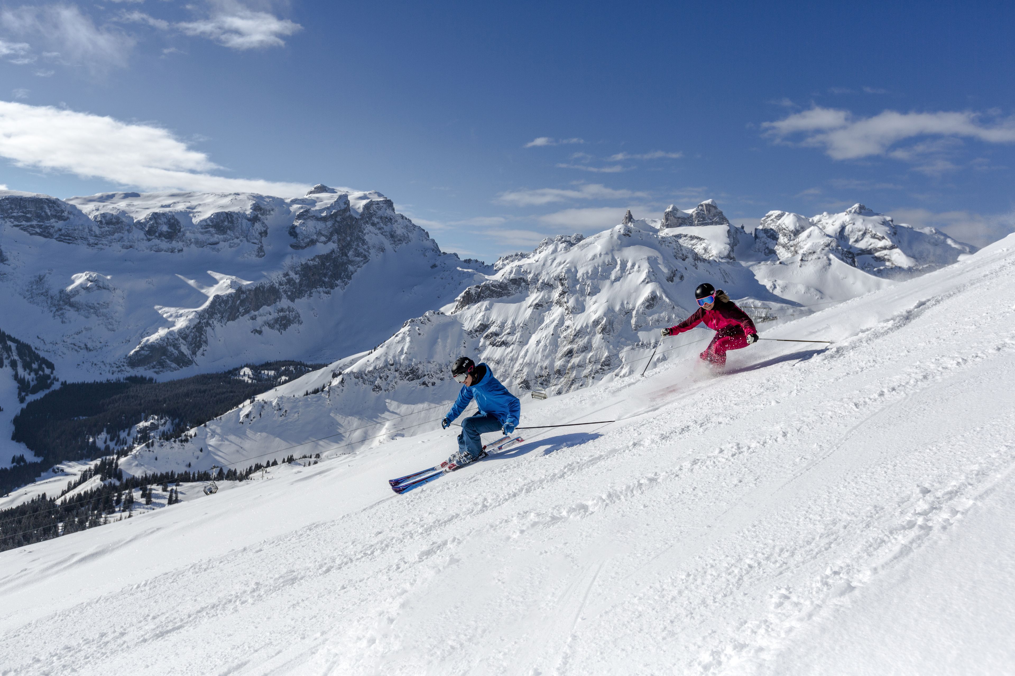 A snowy mountain slope with skiers.